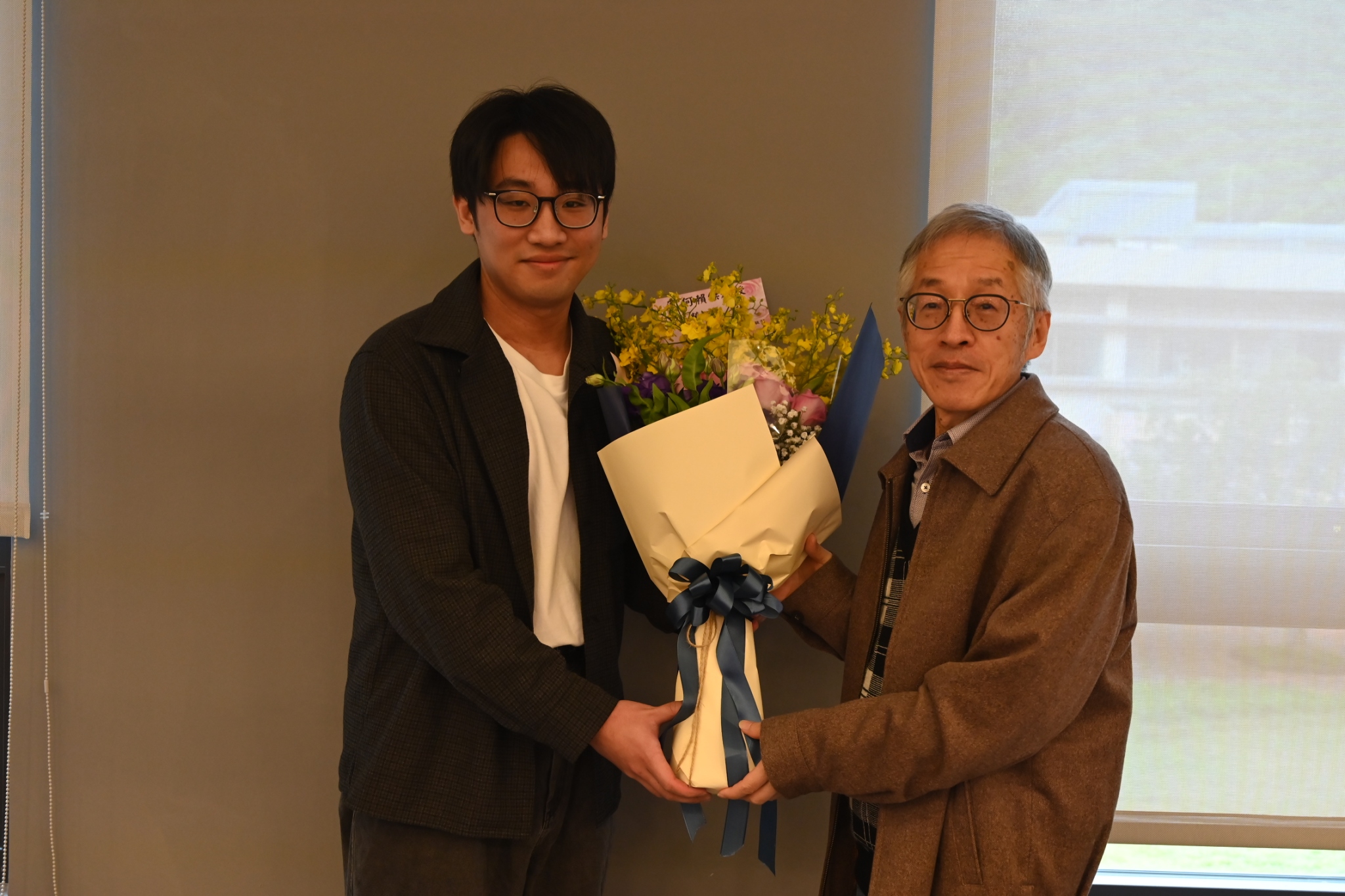 指導學生代表獻花與何賴傑教授(左)。 指導學生代表獻花與何賴傑教授(左)。