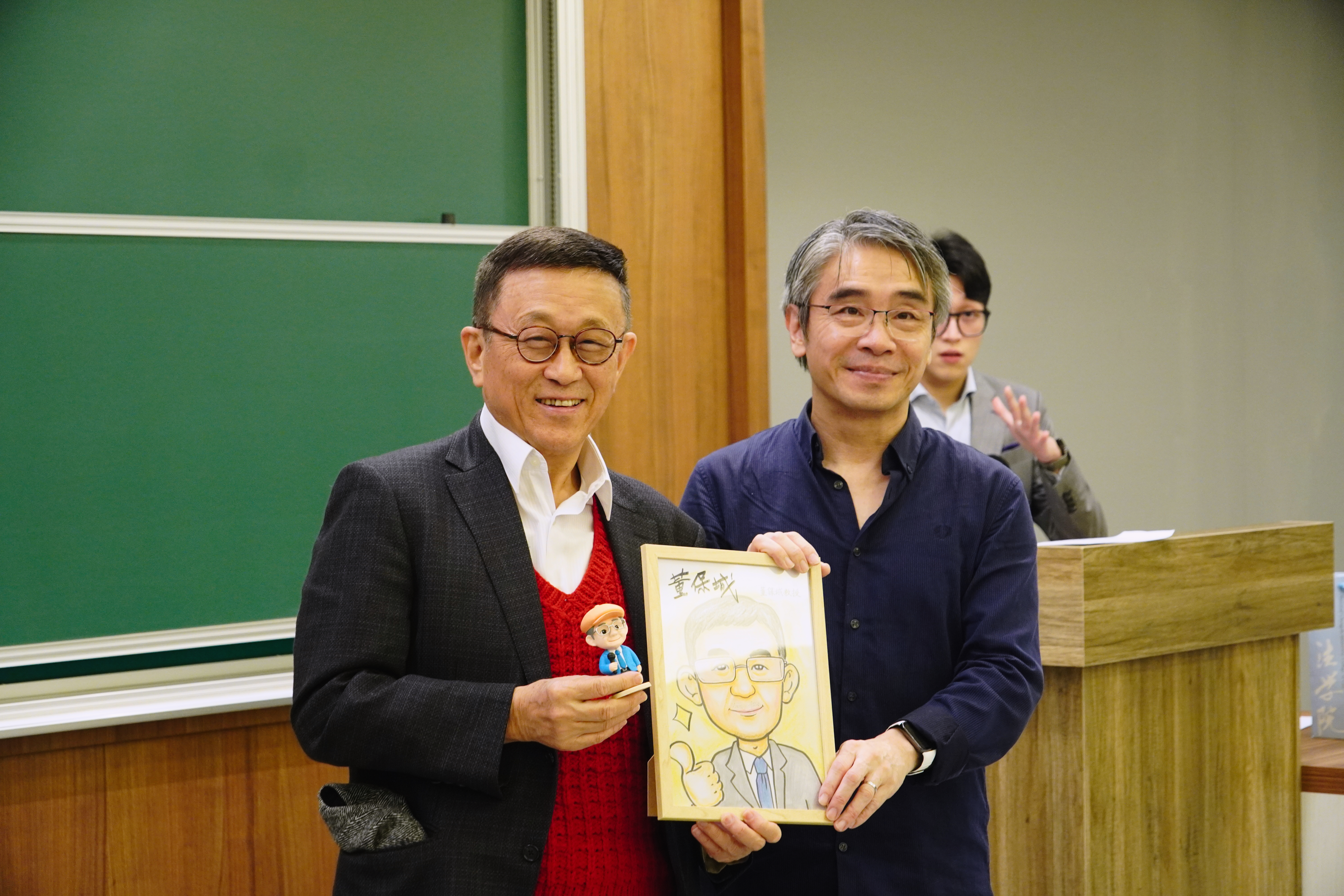 廖元豪副教授（右）頒贈紀念品形象公仔與似顏繪與董保城教授（左）。